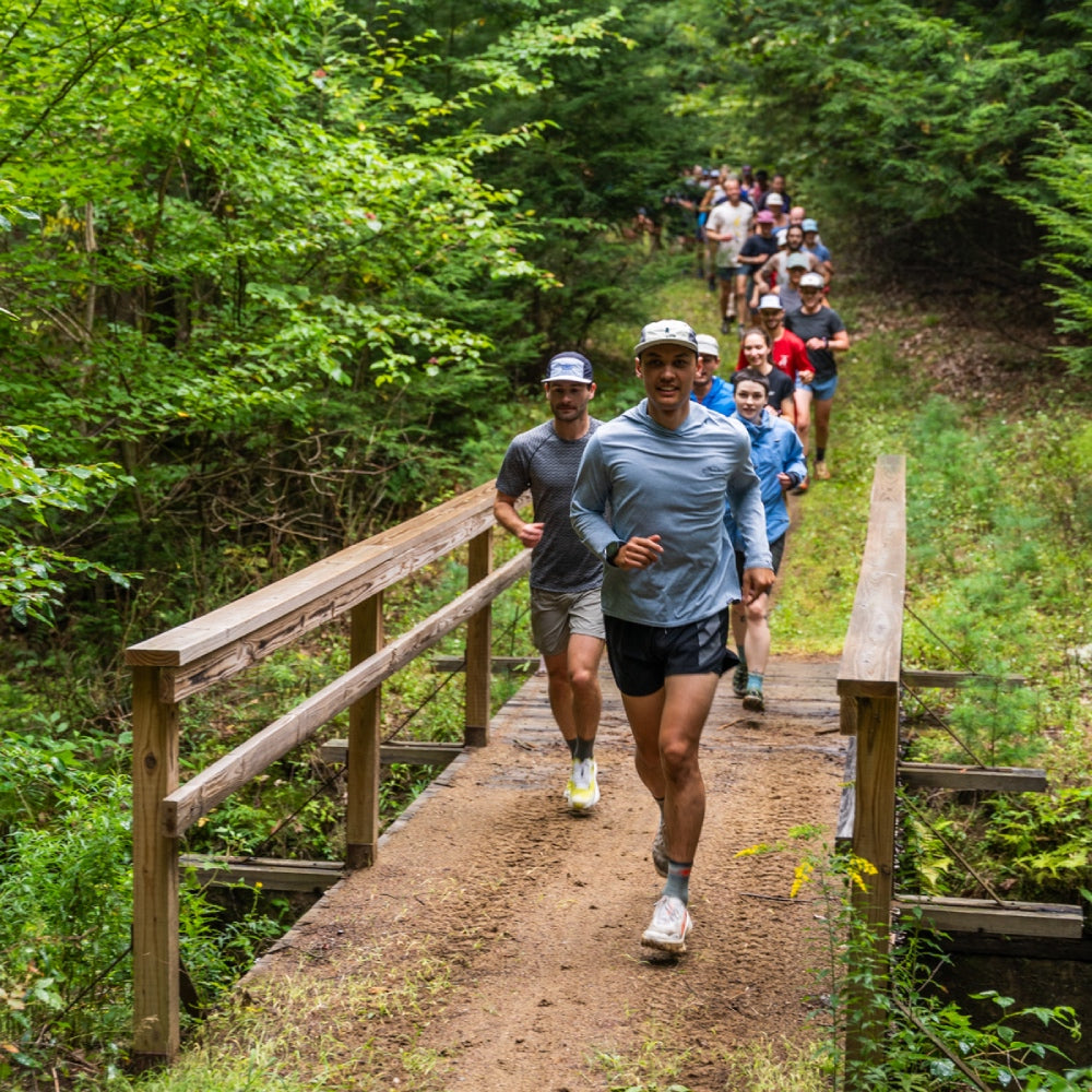 A trail runner in Darn Tough socks leading a group of trail running newbies out for a run