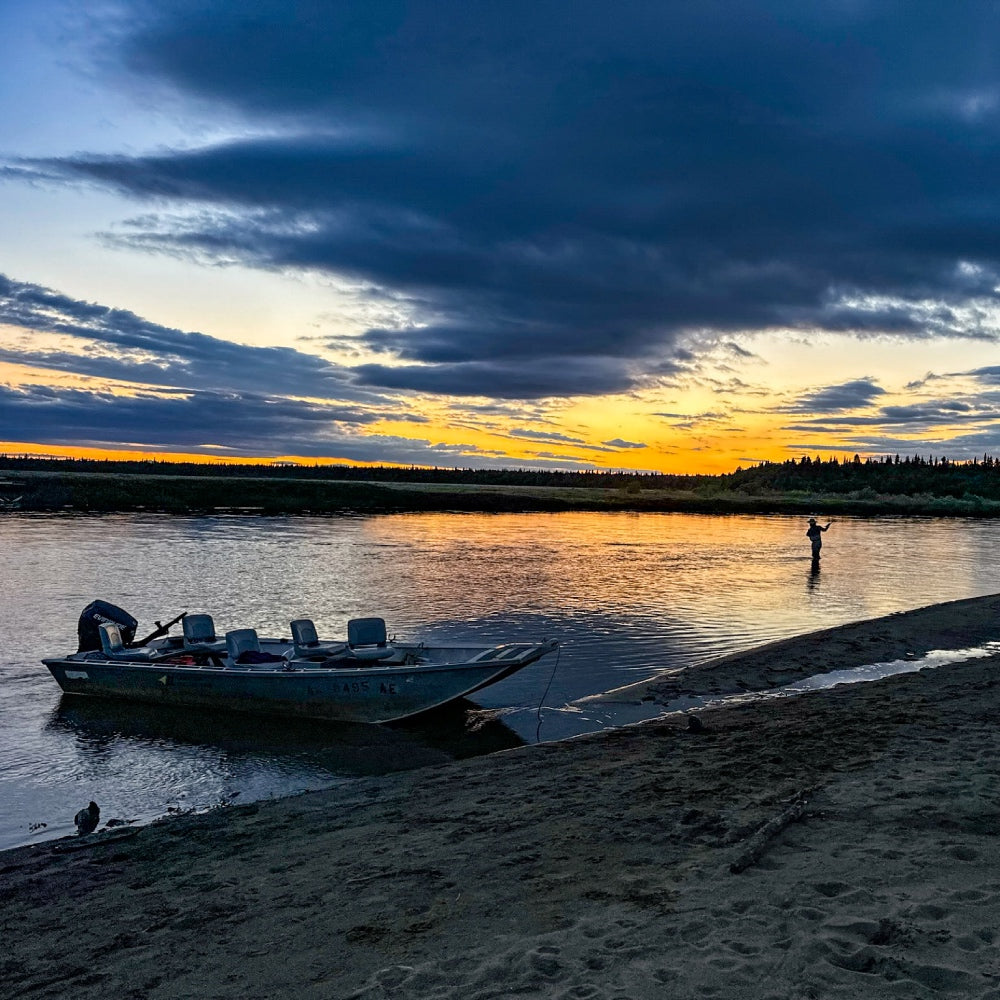 A fly fisher out at sunrise on an abandoned beach