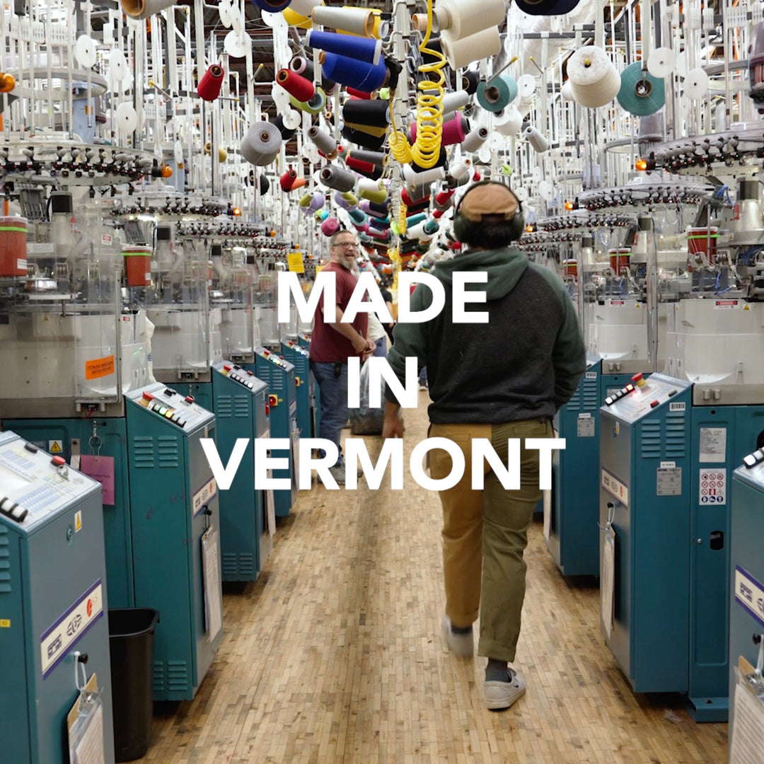 Made in Vermont - a person walking down a row of knitting machines at Darn Tough socks