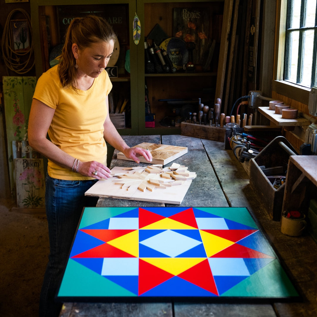 Megan making a Barn Quilt with the Knit to Give inspired Barn Quilt next to her
