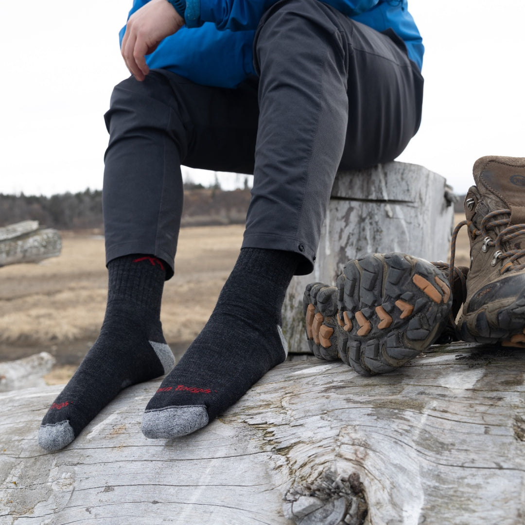 A pair of feet wearing the 1466 hiking socks in black, the sock used to set the world record