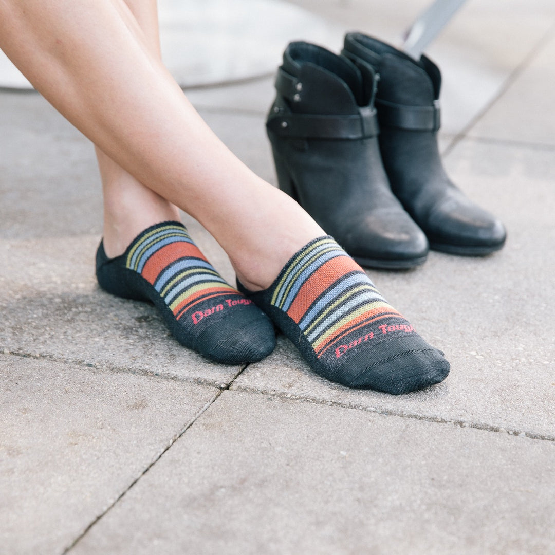 Woman's feet in no show socks about to put on ankle boots, just one reason to wear no show socks