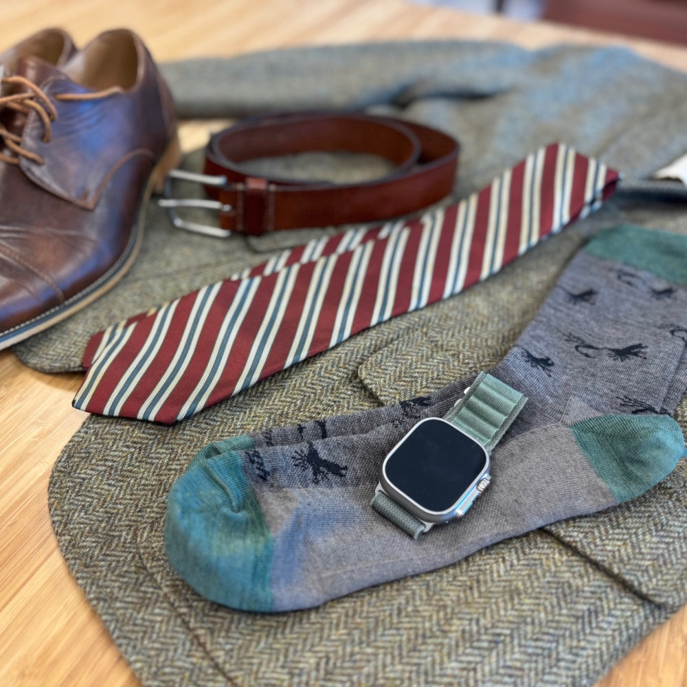 Gray dress socks with light green accents and matching accessories, like a tie and watch