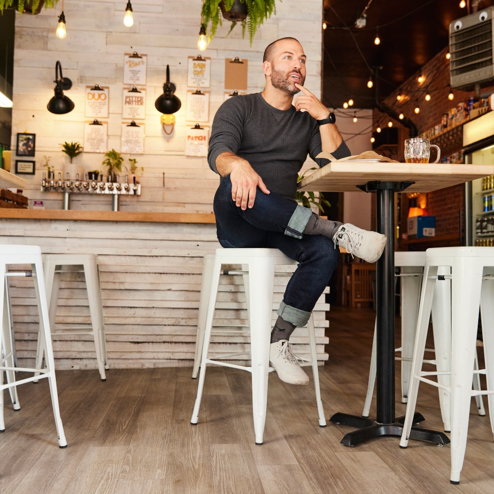 A dad sitting at a table with a beer wearing Darn Tough socks