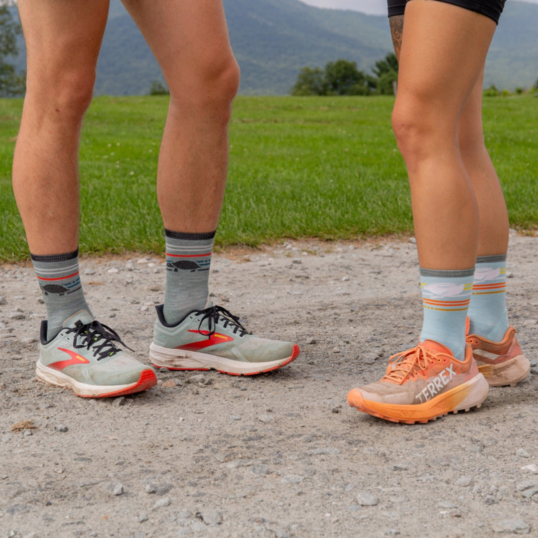 Two runners standing on a dirt road wearing micro crew running socks.