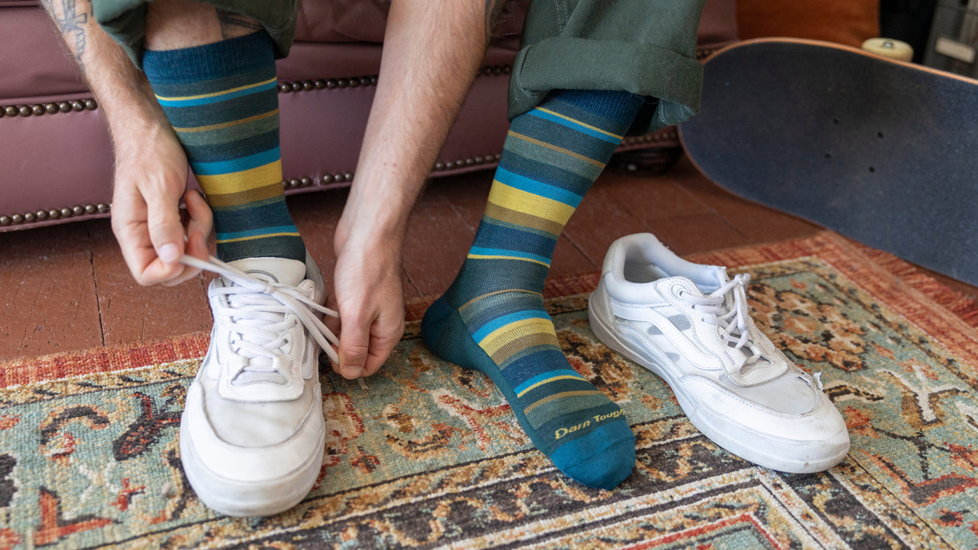 Close up of model putting on shoes and featuring the Men's Oxford Lightweight Lifestyle sock 