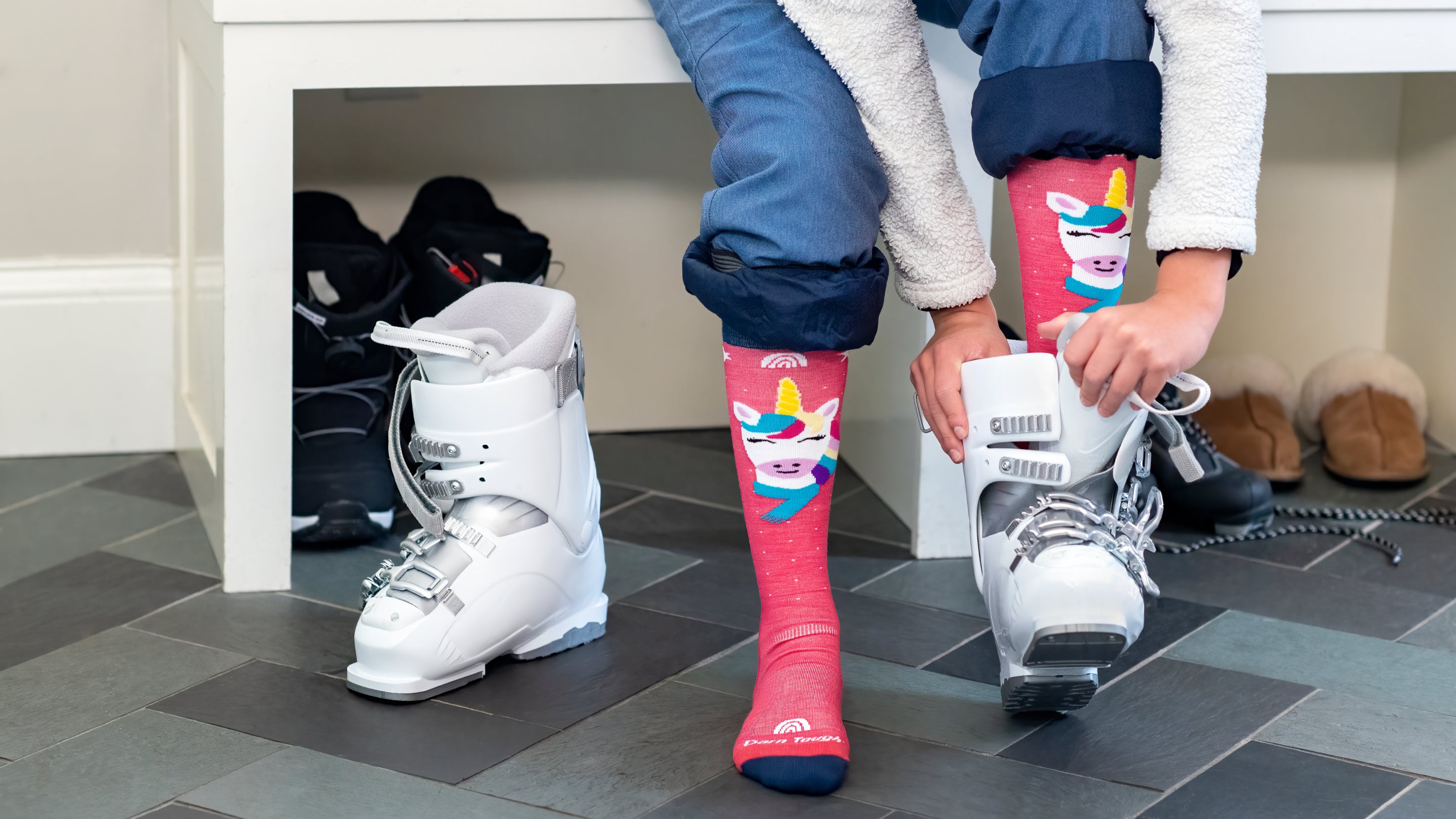 Close up of model putting on ski boot featuring the Kids Magic Mountain Over the calf sock