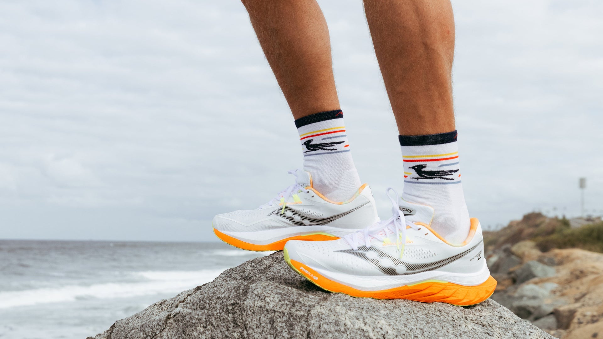 model standing of rock infront of water wearing the front runner micro crew in white 