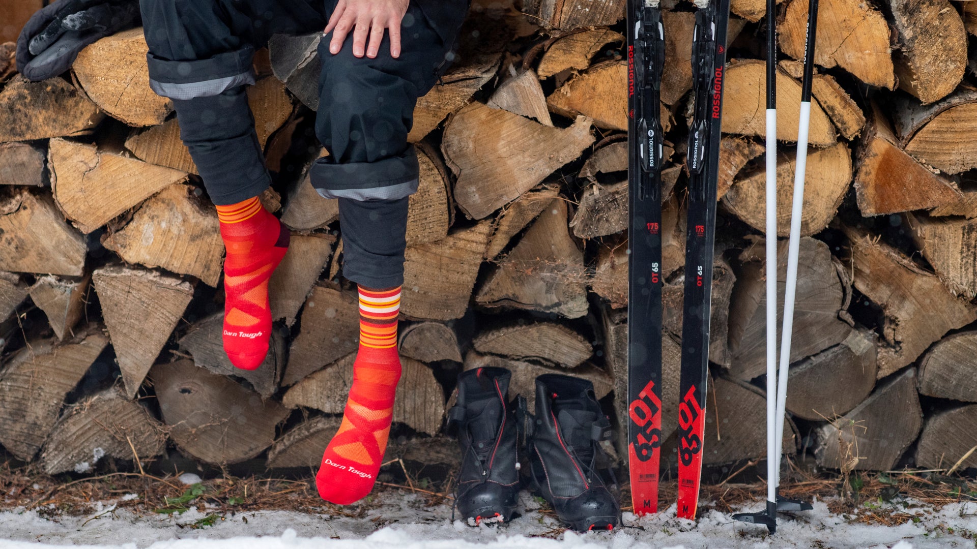 close up on model featuring the Men's Snowpack over-the-Calf ski and snowboard sock in red