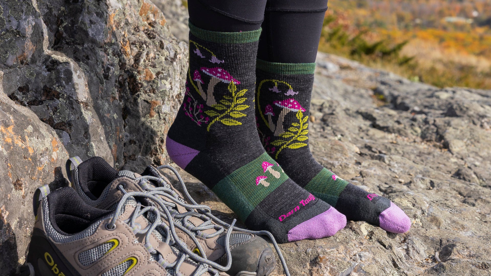 Models feet on rocks next to shoes wearing mellow mushroom sock
