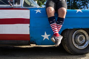 Man seated on truck wearing American flag inspired patriotic socks