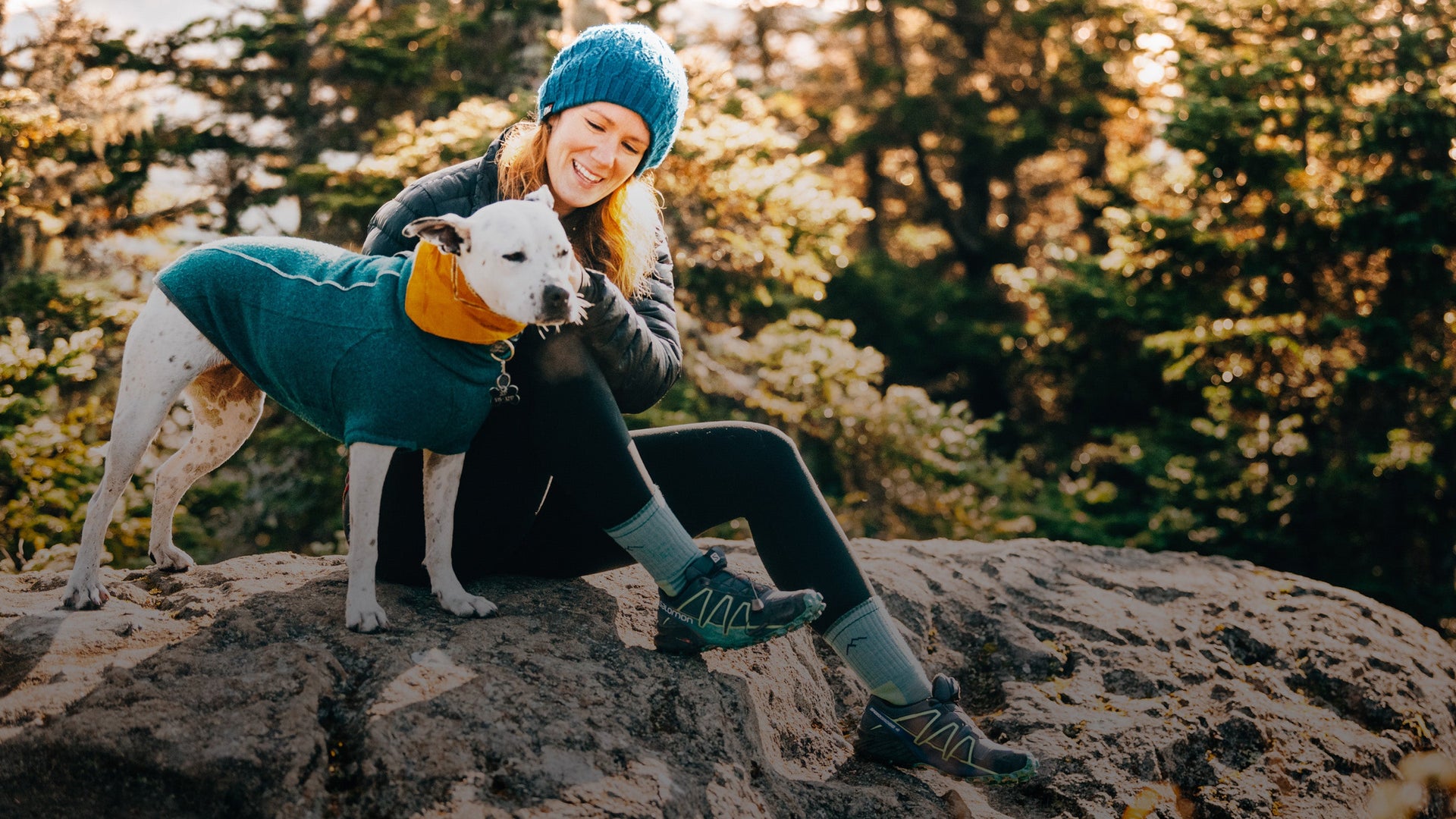 Woman out hiking with her adorable dog. She's wearing blue women's socks
