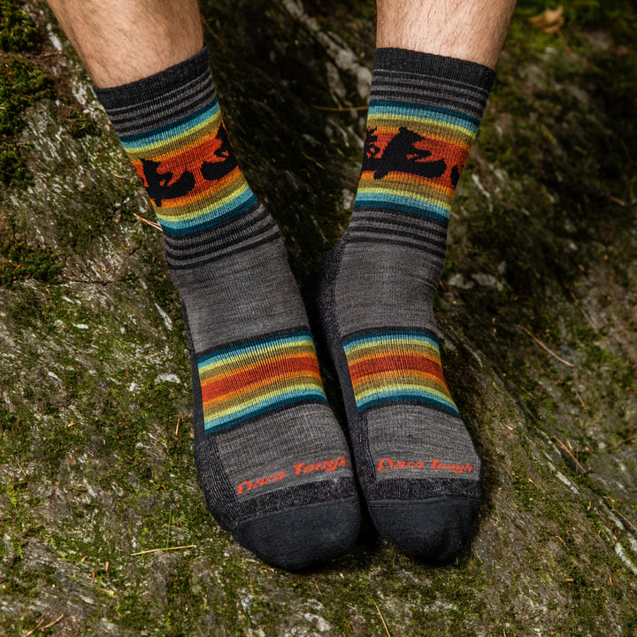 Hiker's feet in the Willoughby hiking socks with a moose and bear canoeing together
