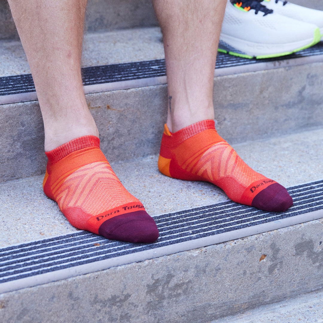 Close up shot of model sitting on concrete steps wearing 1033 socks in Race Red without shoes on