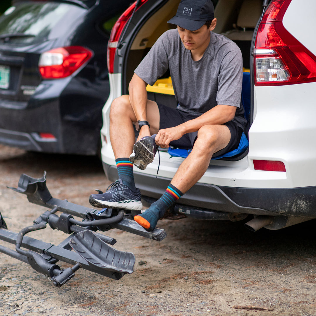 Trail runner getting out of car putting on running shoes over Micro Crew Stride socks