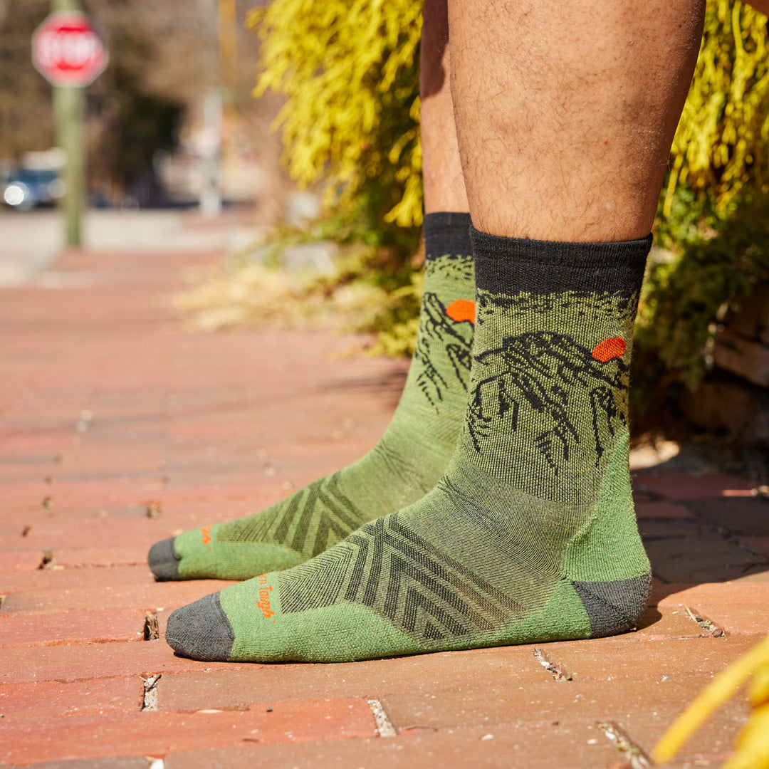 Models feet on Brick ground wearing the Men's Vert Micro crew Running sock in Lichen