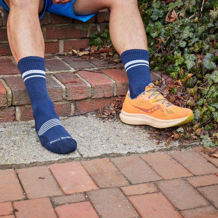 Models feet with one shoe on wearing the 1118 Element Micro Crew Running Sock in Eclipse