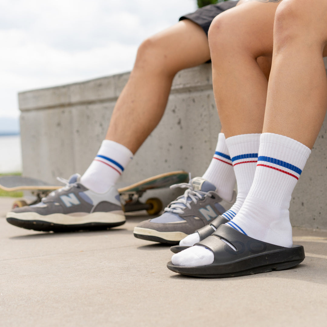 Two Models legs one in sneakers one in slides both wearing the 1118 Element Micro Crew Running Sock in White