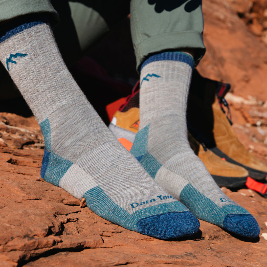 Model wearing 1466 socks in Rye colorway without shoes against red desert rock