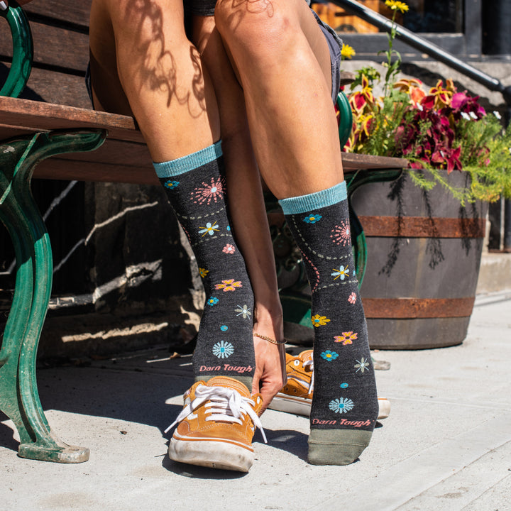 Woman's feet wearing the Twisted Garden floral socks in gray with aqua flowers