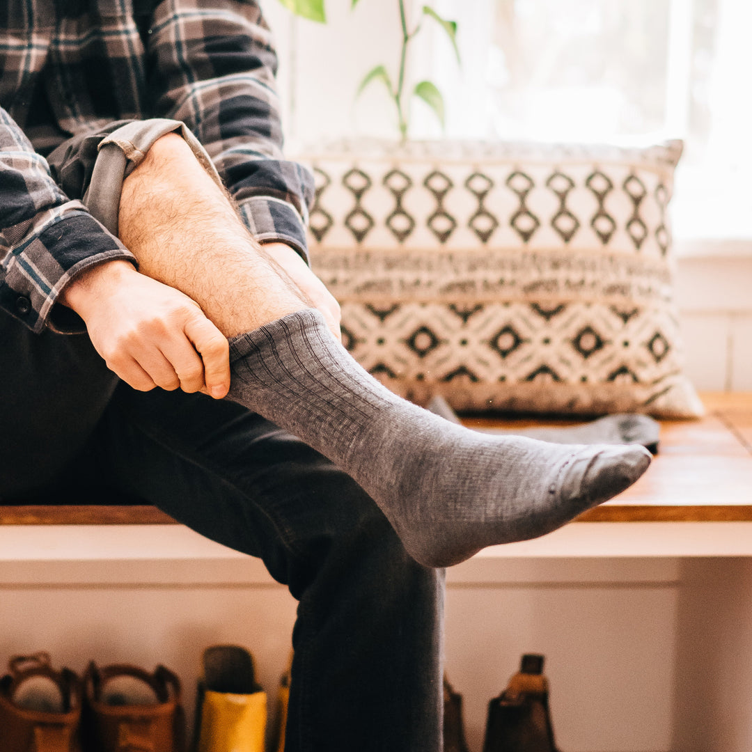 Image of a man pulling up his Standard Crew Lifestyle sock in Medium Gray, Lifestyle Image