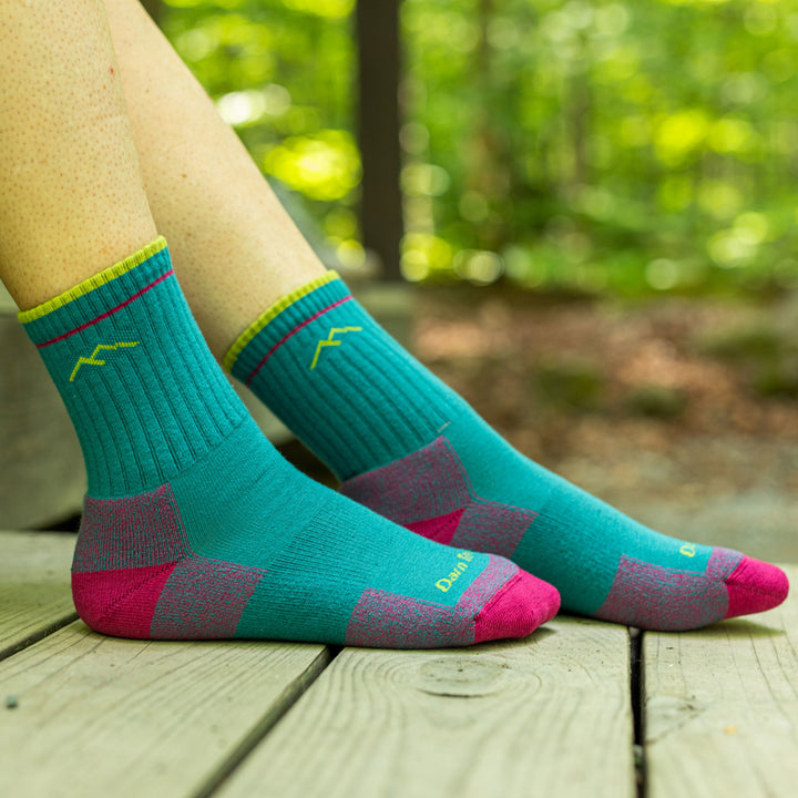 Close up of woman's feet on a wooden porch in the woods wearing Coolmax Hiker Micro Crew Midweight Hiking Socks in Teal