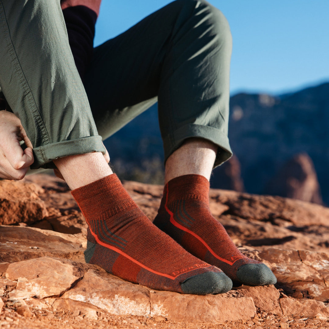 Model wearing 1959 socks in Chestnut colorway without shoes on red desert rocks