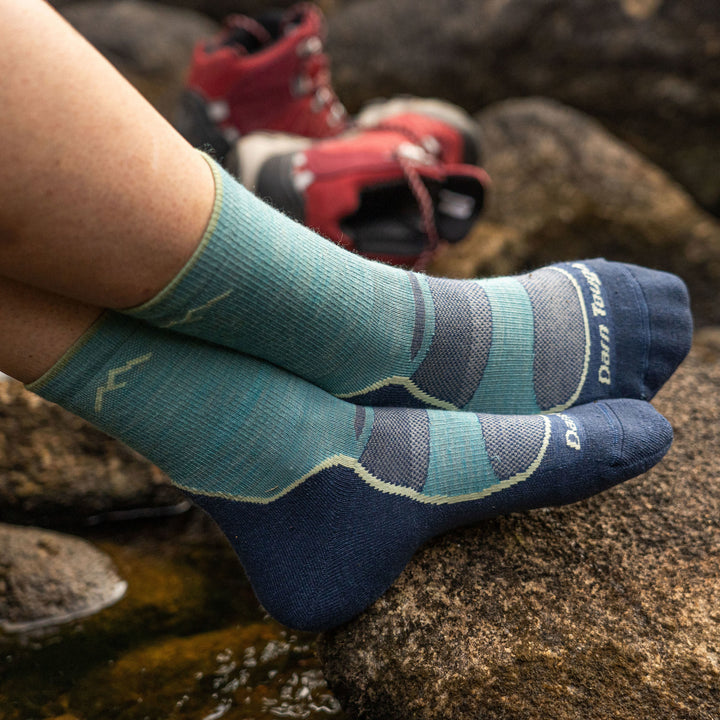 Woman rests her feet on a rock, ankles crossed with hiking boots in the background, wearing Women's Light Hiker Micro Crew Lightweight Hiking Socks in Aqua, Lifestyle Image
