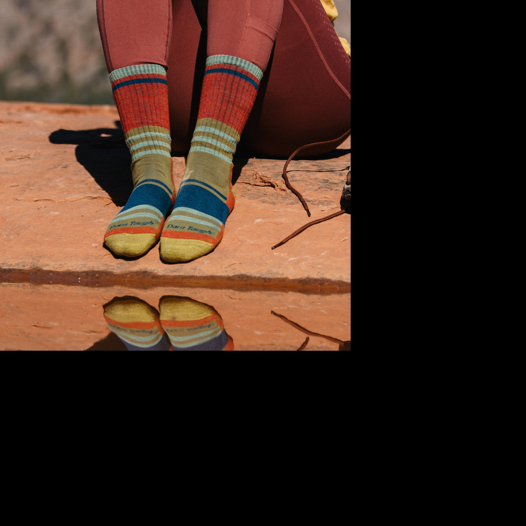 Model wearing 1968 socks in Saandstone colorway without shoes against red desert rocks