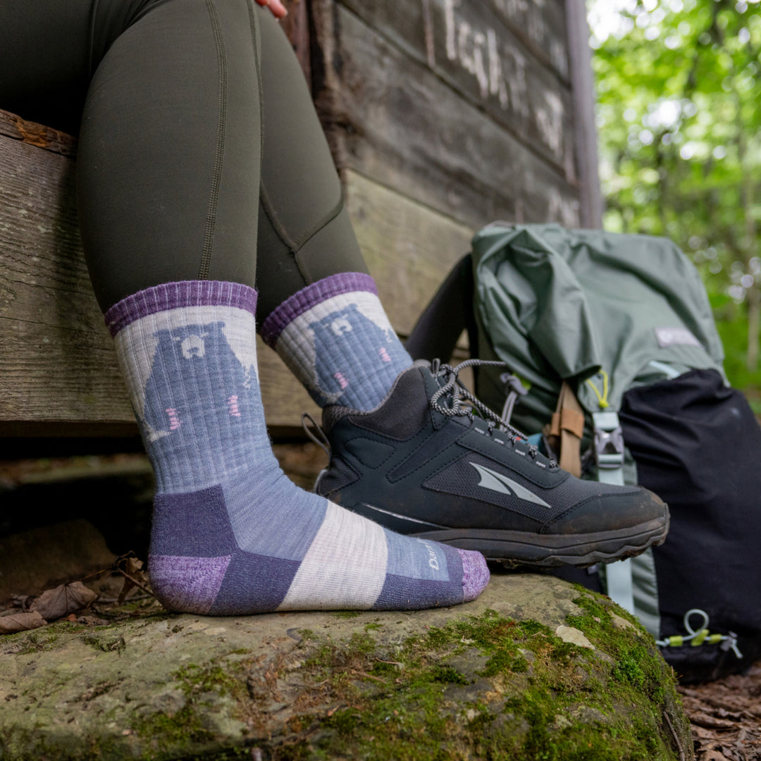 model sitting in doorway with feet on rock with one shoe on the other foot wearing the beartown in Fog