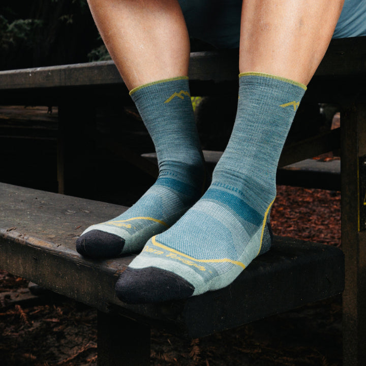 Models feet on wood stairs wearing the 1972 Light Hiker Micro crew Hiking sock in Seafoam