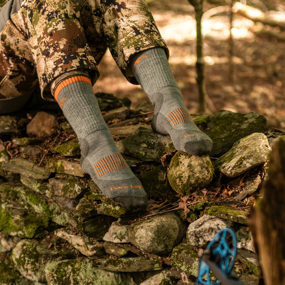 close up on model image of feet on rocks wearing the 2107 seafoam