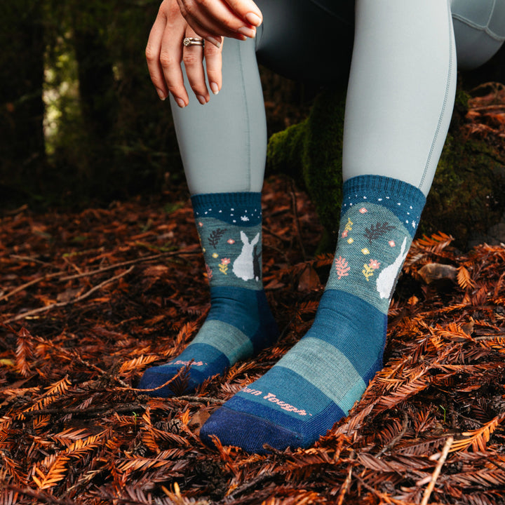 Models feet on wooded ground wearing the 5001 Critter club Micro Crew hiking sock in Eclipse