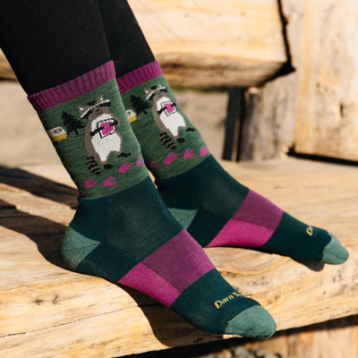  On model Image of the 5001 Critter club in Moss with feet rest on wooden bench