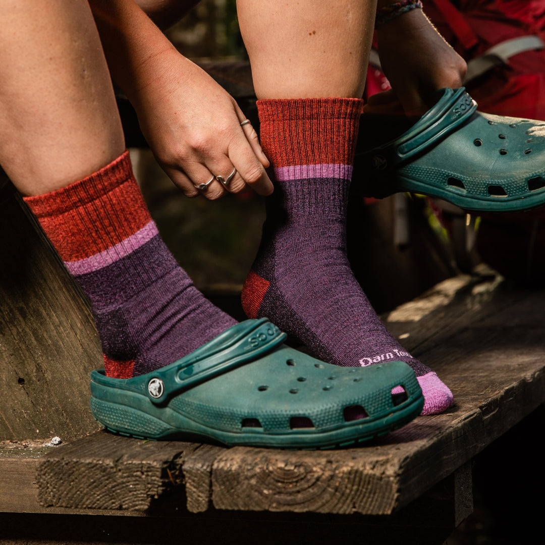 Hiker putting on crocs over the Ranger super soft hiking socks in plum purple