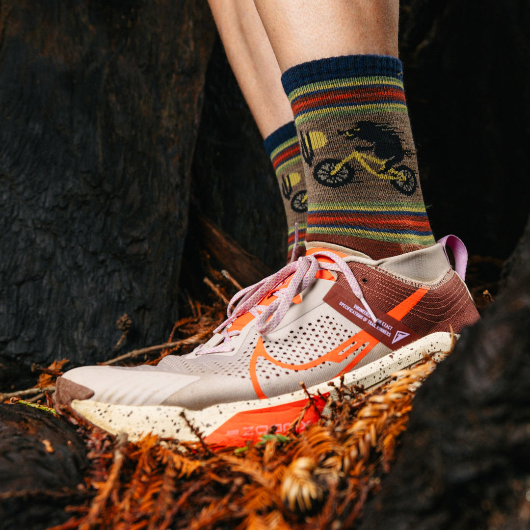 Models feet on wooded Ground in running shoes wearing the 5003 Willoughby Micro Crew hiking sock in Chestnut