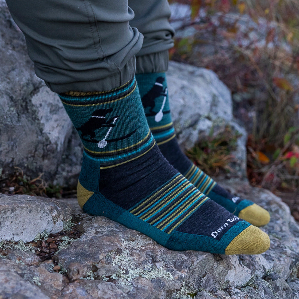 Close of of models feet on rocks wearing the 5003 Willoughby micro crew hiking sock in dog pond green colorway