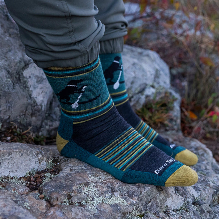 Close of of models feet on rocks wearing the 5003 Willoughby micro crew hiking sock in dog pond green colorway