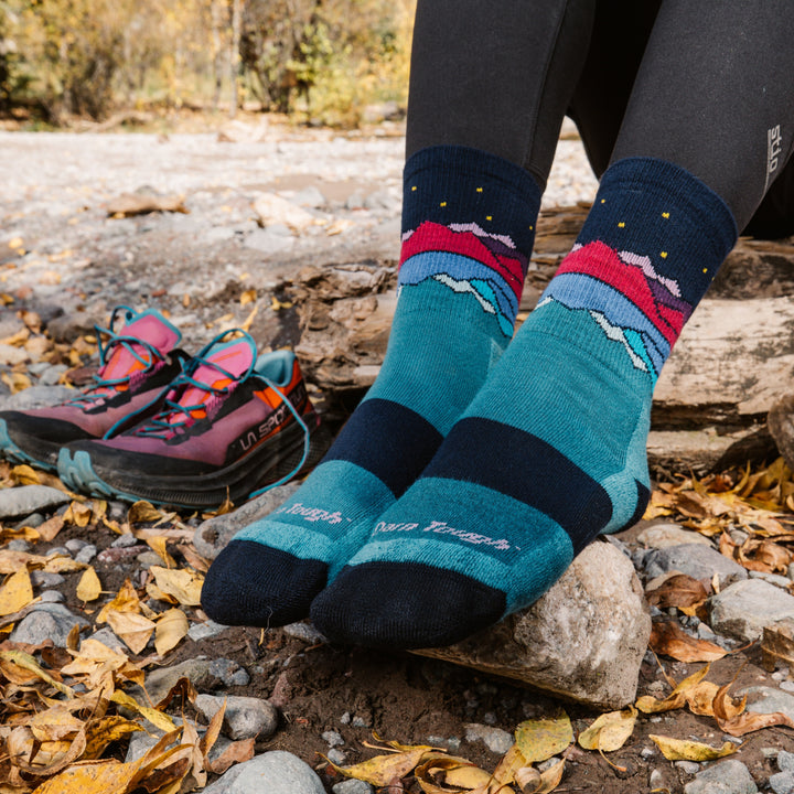 models feet on a rock wearing the 5025 Mirror lake micro crew in Teal colorway 