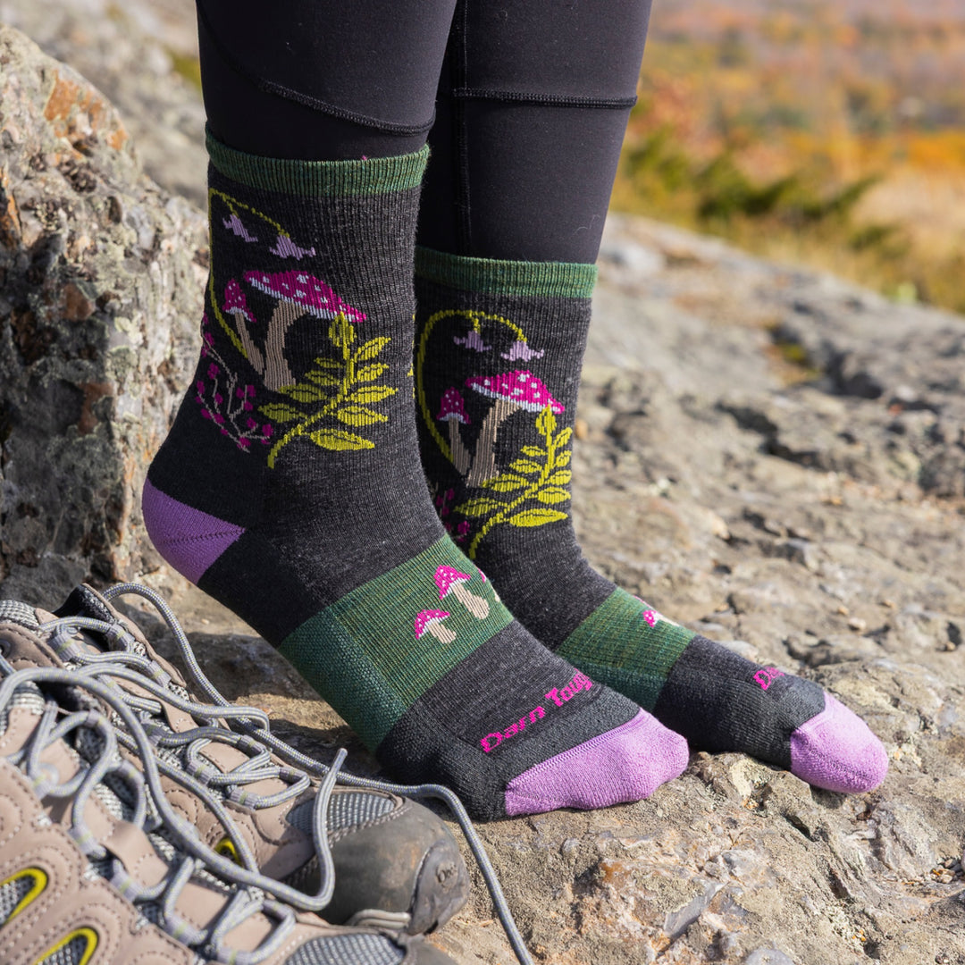 close up of models feet on rock mountainside wearing the 5026 mellow mushrooms micro crew hiking sock in charcoal colorway