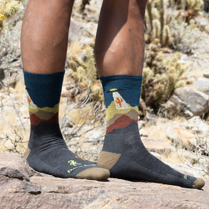 close up of models feet in desert wearing 5051 spaced out lightweight micro crew hiking sock in charcoal colorway