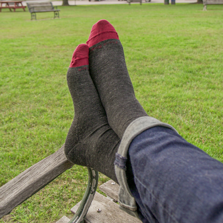 up close on model with feet up on bench wearing the 6032 Solid crew in charcoal featuring red toe and charcoal body
