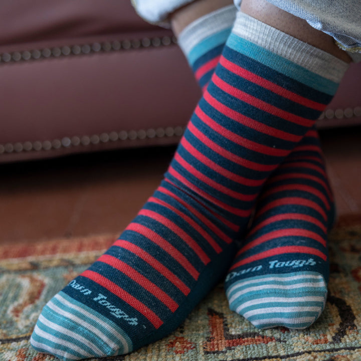 Close up shot of model wearing women's morgan crew lifestyle sock in dark teal with feet crossed