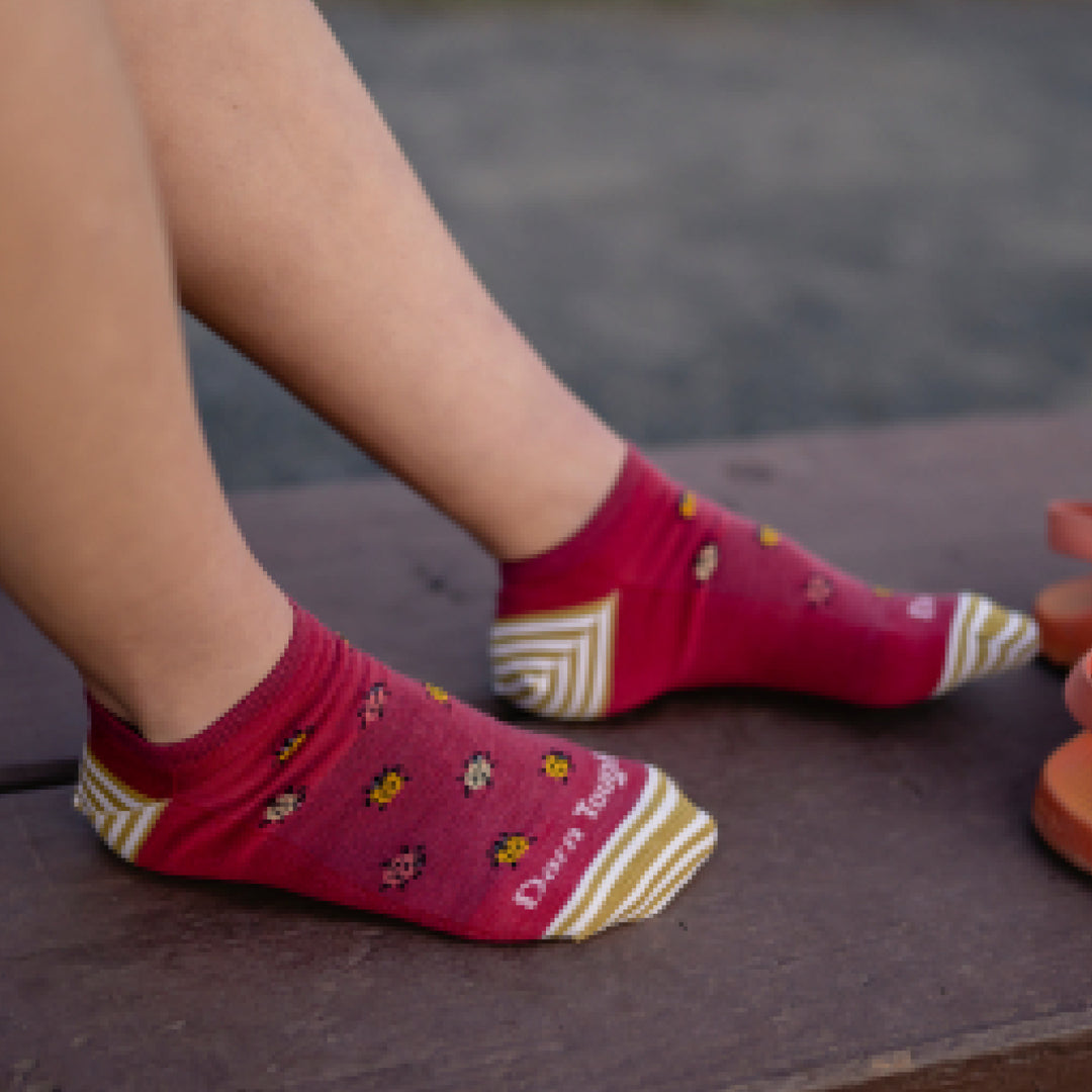Close up shot of model wearing 6074 socks in cranberry colorway without shoes 