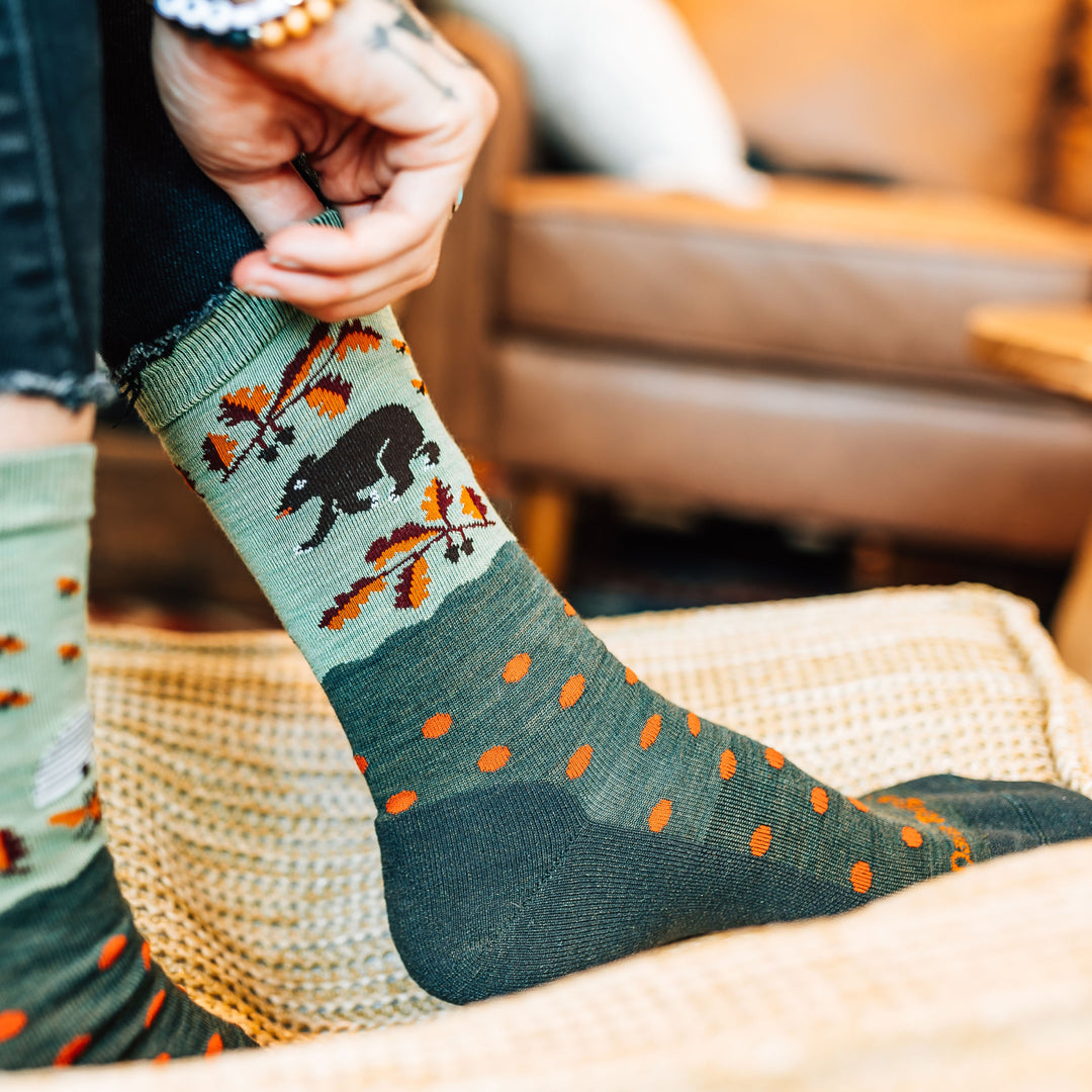 Closeup of Model's feet on the couch wearing the Women's Wild Life Crew Lighteweight Lifestyle Sock