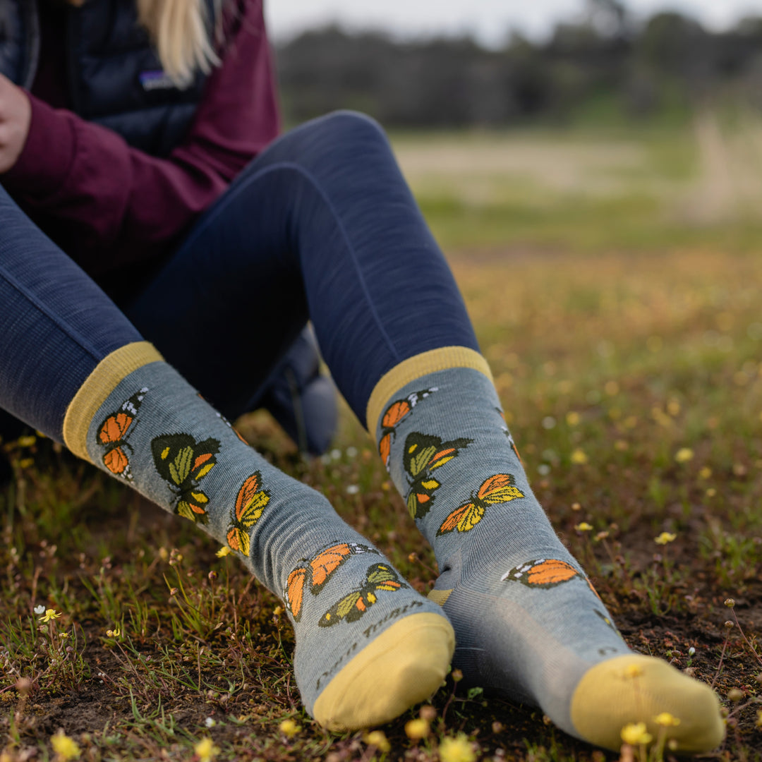 Close up shot of model sitting in a meadow wearing 6109 socks in Seafoam colorway without shoes