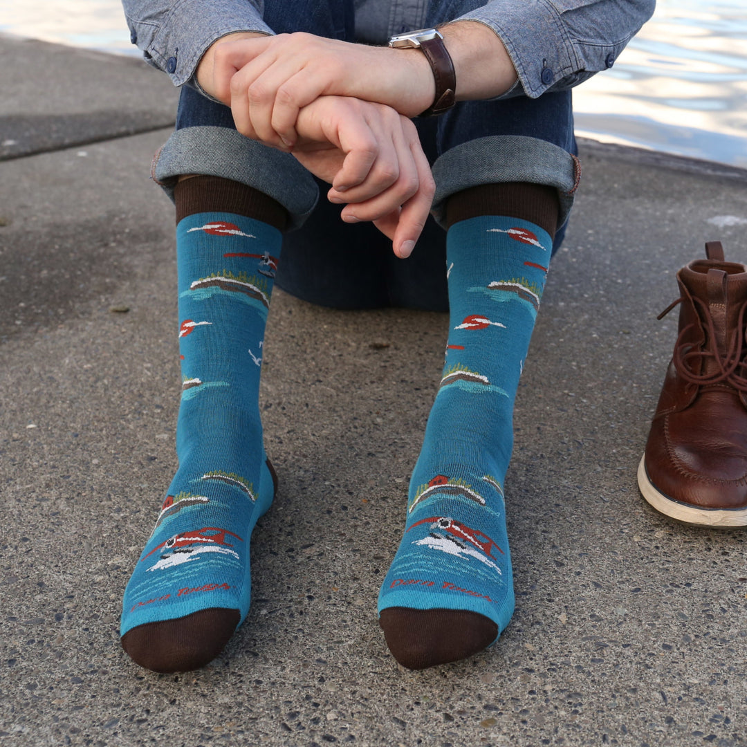 Model sitting on the ground wearing the 6120 Float Boat Crew Lifestyle Socks in Cascade