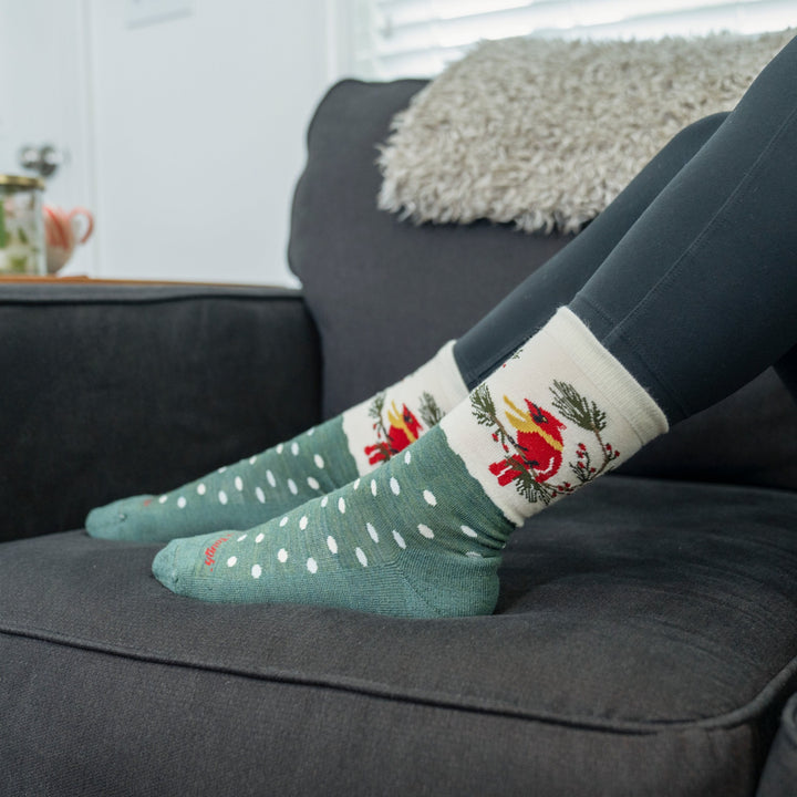 on model image of feet up on couch wearing the 6209 Wildlife crew sock in evergreen