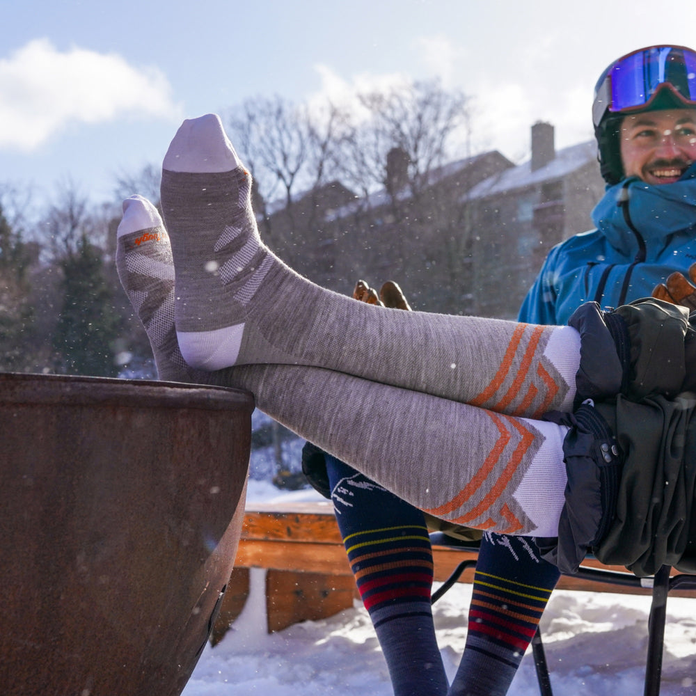 model sitting outside in snow with feet up featuring the 8035 peaks RFl in biscotti