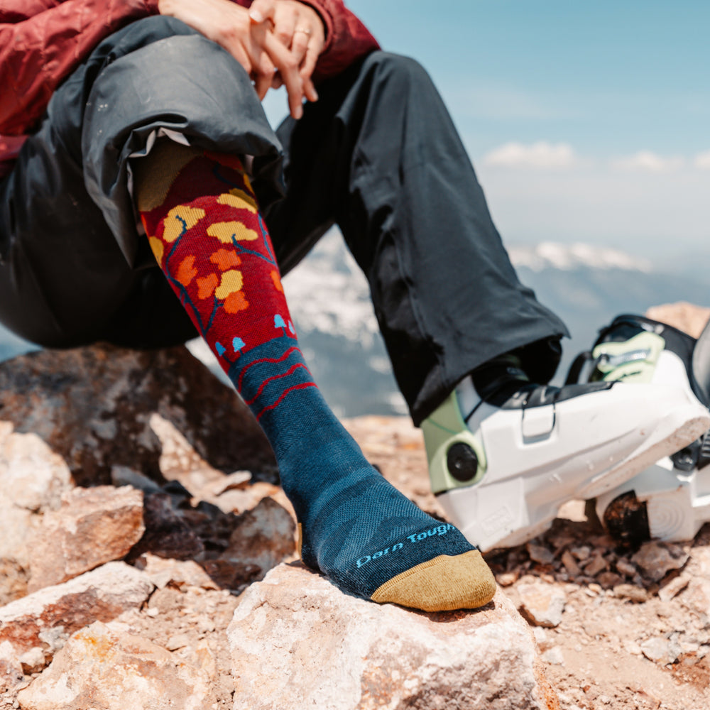 close up on model of 8046 Autumn front foot resting on rock and back foot in ski boot 